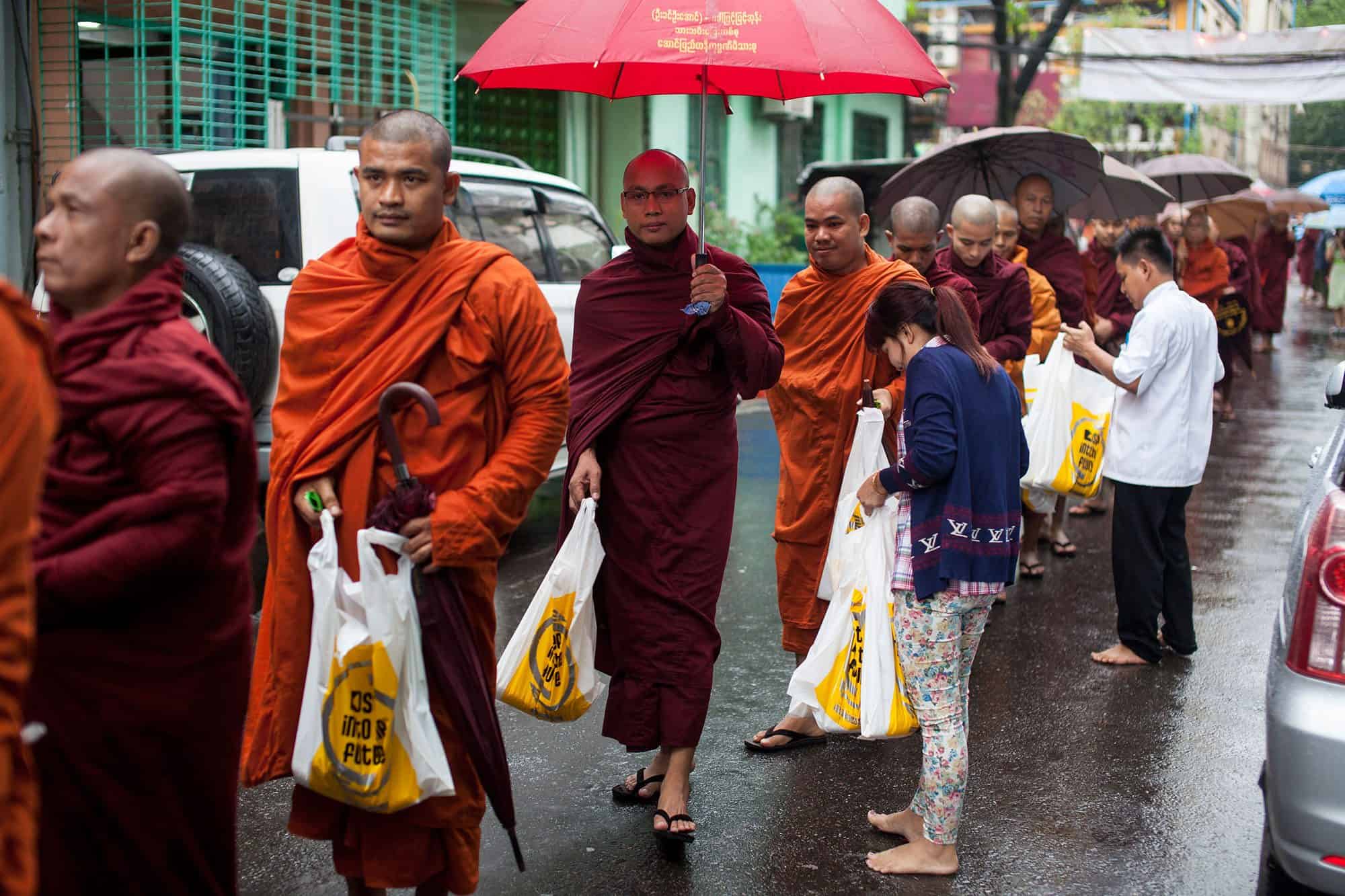 排列有序的僧侣在旅馆门前缓缓经过，所经之处，都有人陆续将一袋袋的物品，恭敬交到每一位僧侣的手中。